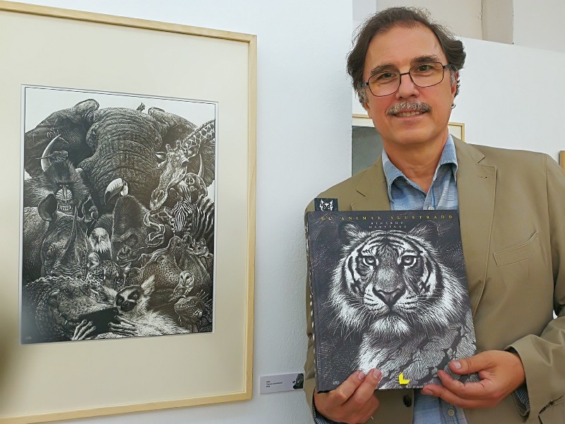 Autor de "El animal ilustrado" sosteniendo un ejemplar